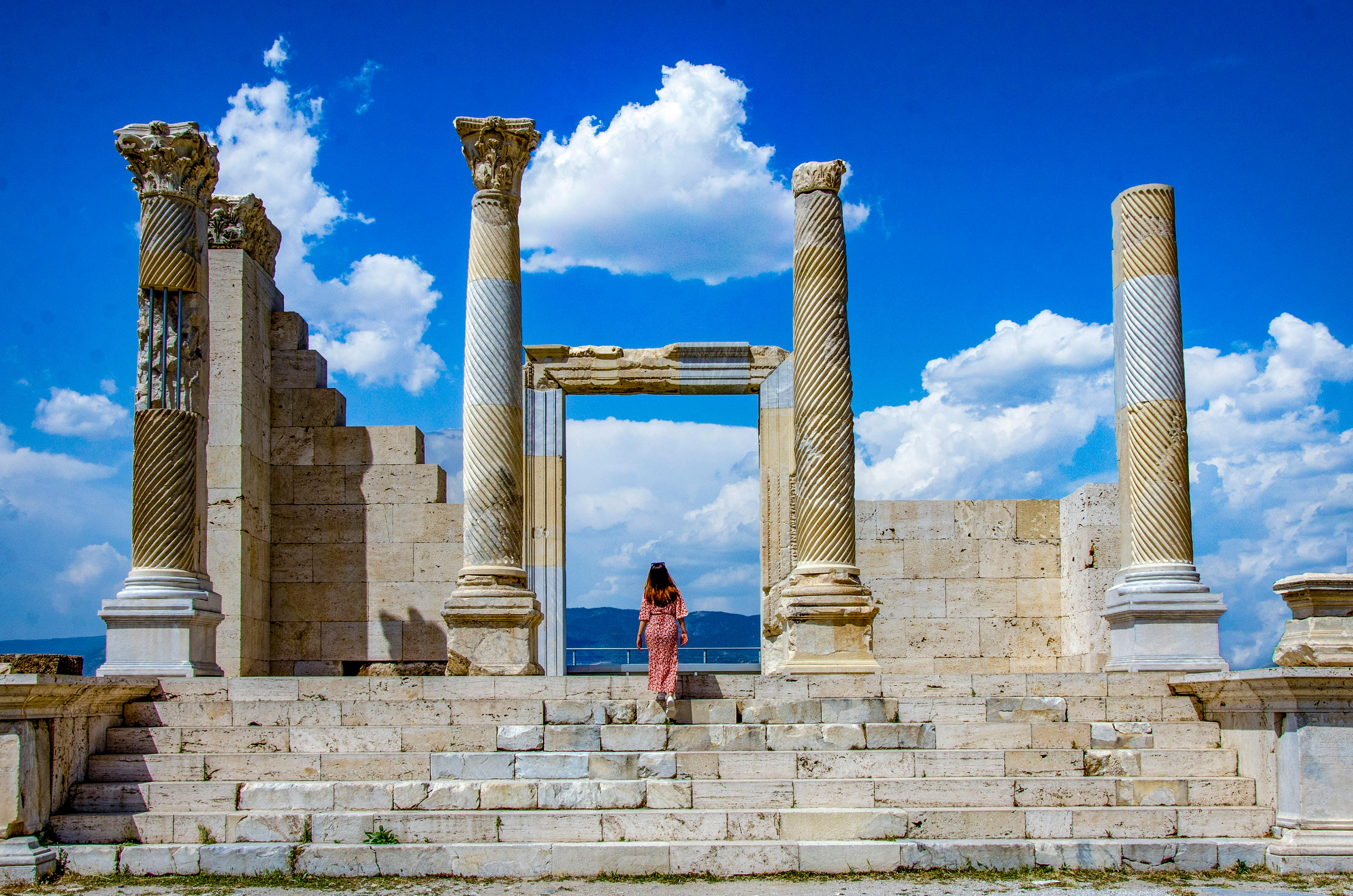 Woman walking among ancient columns at an archaeological site in Denizli, Turkey.