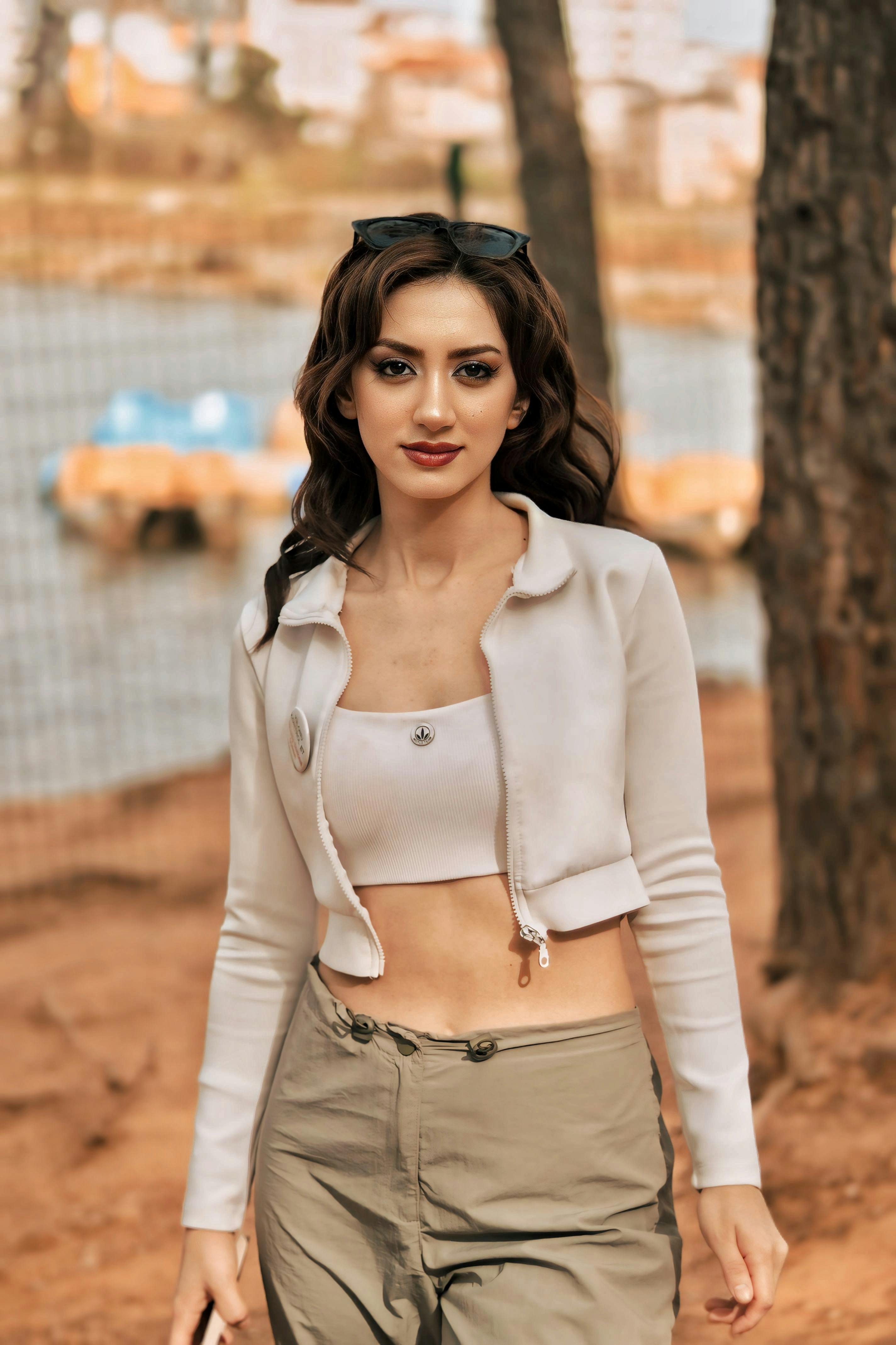 Woman in casual fashion walking outdoors with a stylish outfit and wavy hair.