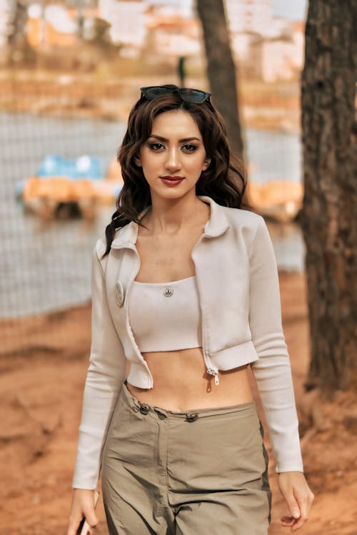 A woman in a white crop top and cargo pants