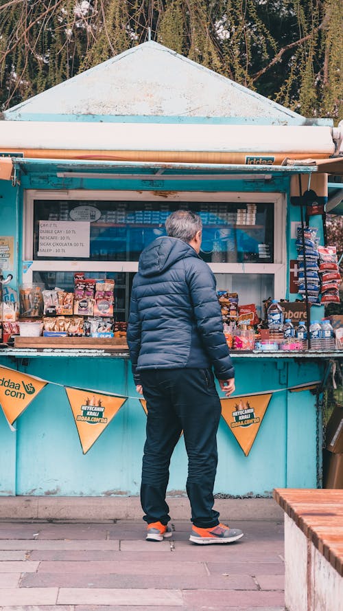 A man standing in front of a food stand