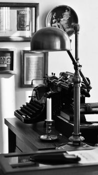 Classic black and white photo featuring a vintage typewriter on a desk.
