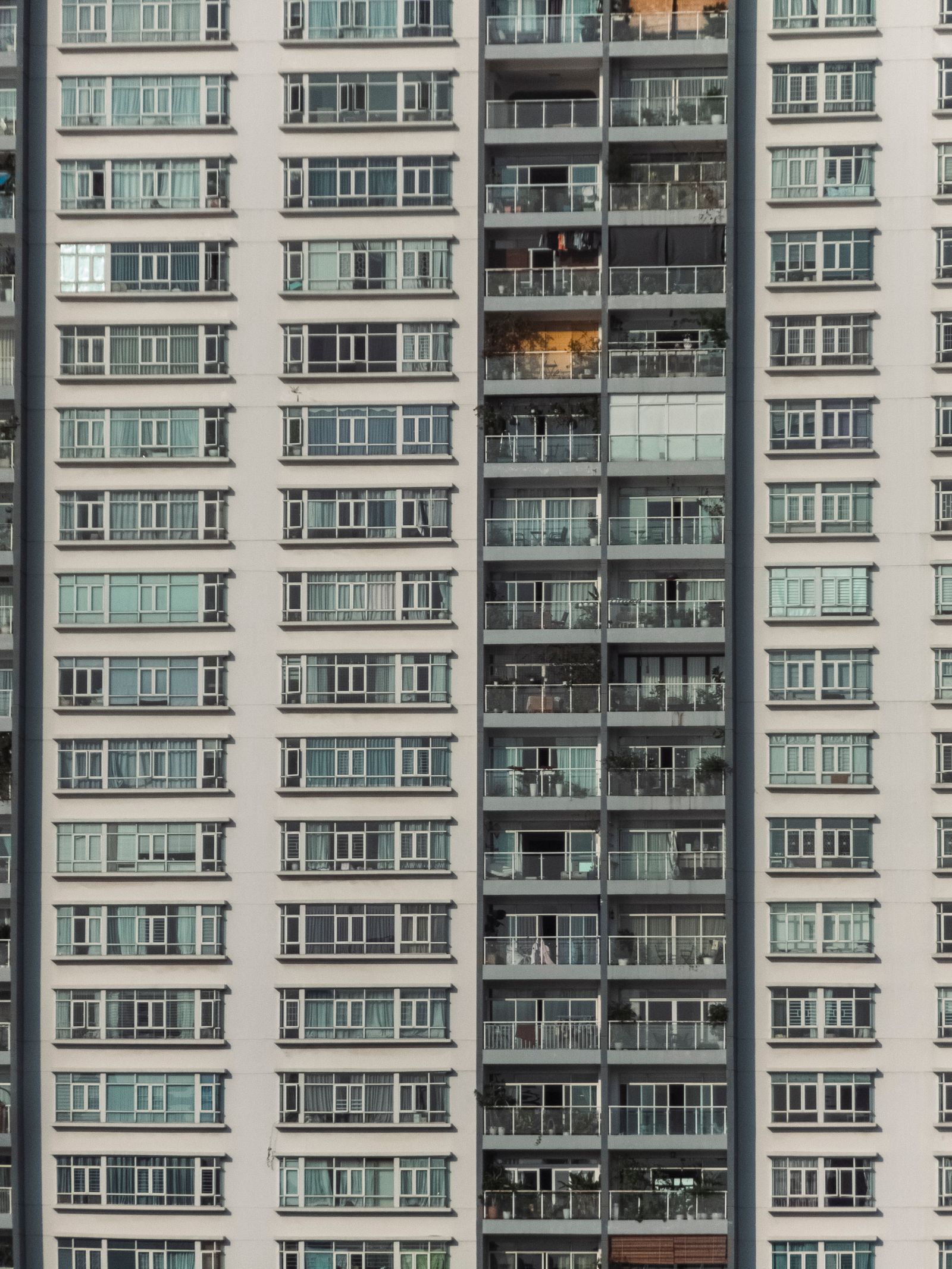 Detailed view of an urban high-rise apartment building with balconies and windows.