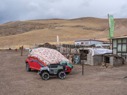 A car parked in front of a tent and a building