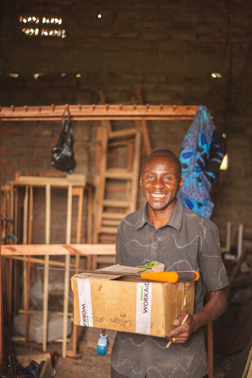 A man holding a box of goods in a room