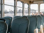 一艘客运渡轮内部，空着的座位俯瞰着水面的城市天际线