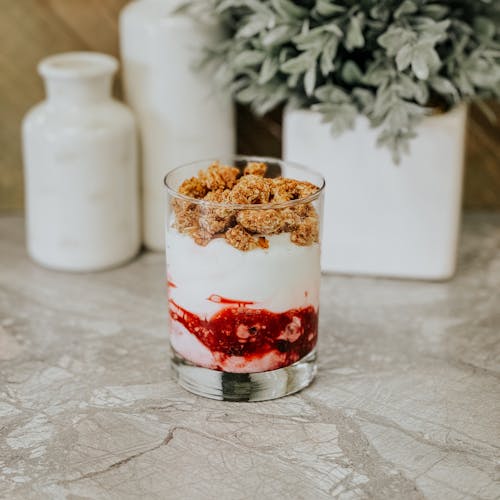 Free Dairy Dessert with a Berry Sauce, and White Porcelain on a Marble Table Stock Photo