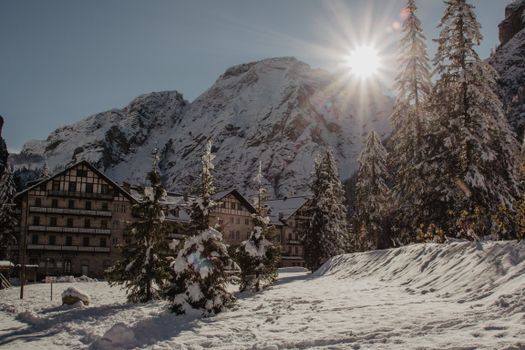 Scenic winter landscape with snow-covered mountains and houses in Trentino-Südtirol, Italy.