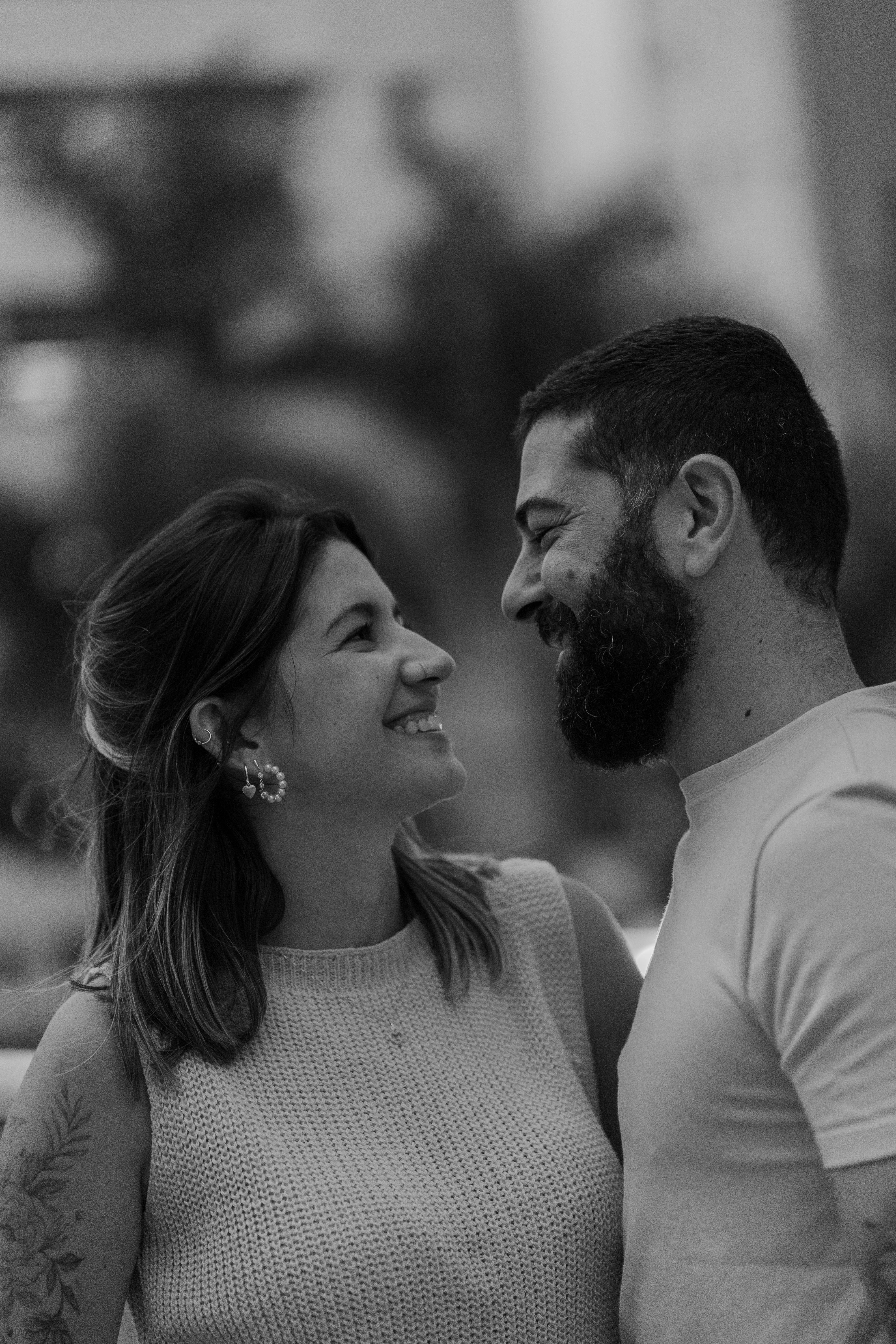 Black and white photo of a happy couple smiling at each other, capturing joy and connection.