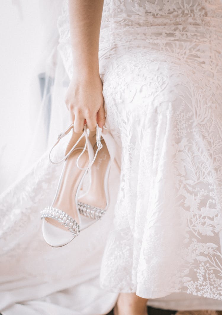 Woman In White Gown Carrying White Sandals