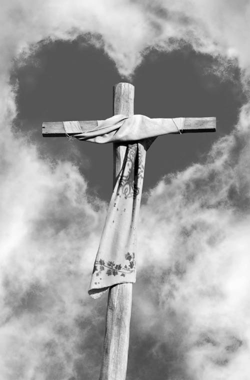 A black and white photo of a cross with a heart in the middle