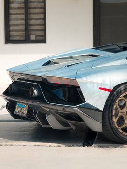 A luxury Lamborghini Aventador parked outside a modern house, showcasing its sleek design.