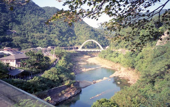 A picturesque view of Houtong Bridge spanning a lush valley river in Taiwan.