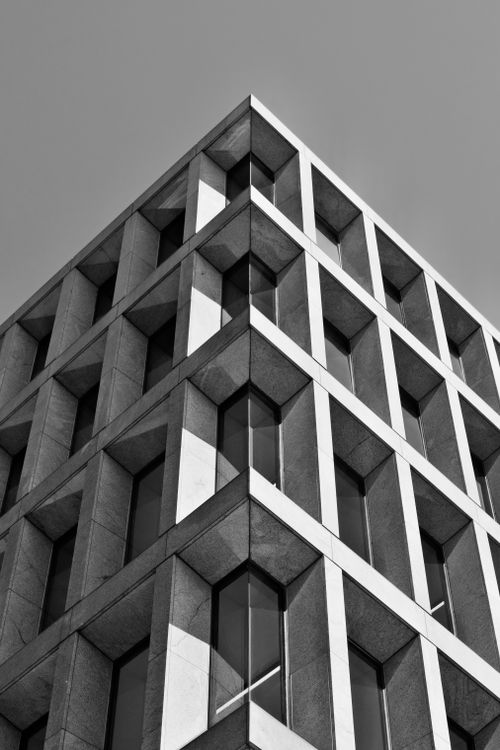 Free Elegant corner view of a modern building with geometric windows in black and white. Stock Photo