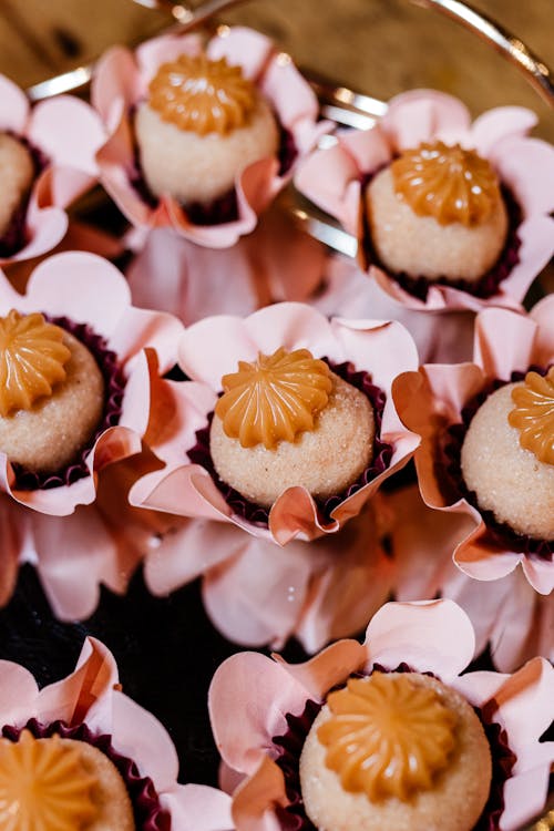 A tray of small cakes with pink flowers