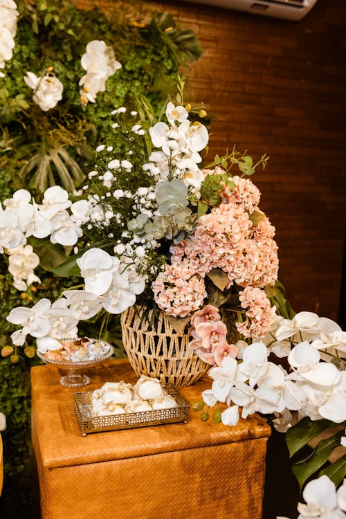 A floral arrangement on a table with a vase of flowers