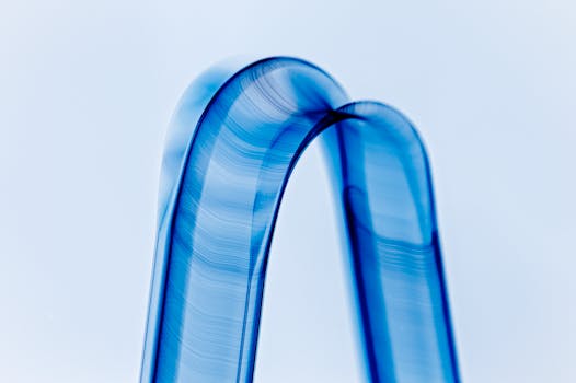 Dynamic abstract image featuring a smooth, flowing blue metallic wave with a minimalist aesthetic.