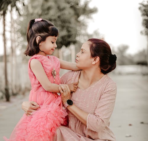 A woman and a little girl sitting on the ground