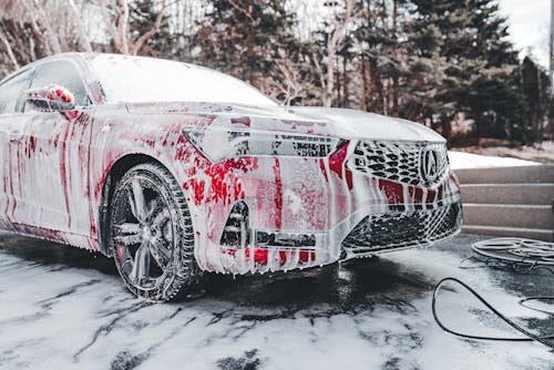 A car covered in snow and water with a red and white paint job