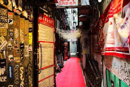 A narrow alleyway with a red carpet and graffiti