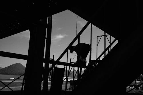 A black and white photo of a man standing on a stairway