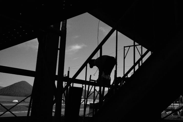 Silhouette Of A Person Working On A Coastal Construction Frame