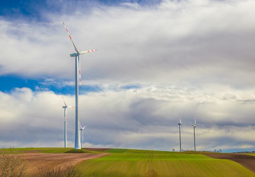 Free Beautiful rural scene with wind turbines generating renewable energy on a cloudy day. Stock Photo