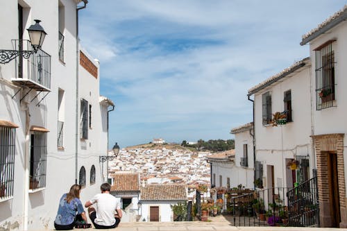 Two people sitting on the steps of a town