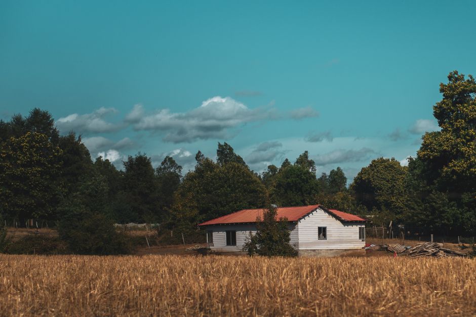 Encantadora casa rural en medio de campos y árboles en El Carmen, Ñuble, Chile bajo un cielo azul.