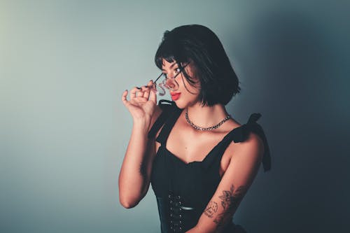 Free Studio Shot of a Young Brunette with Tattoos Wearing Eyeglasses Stock Photo