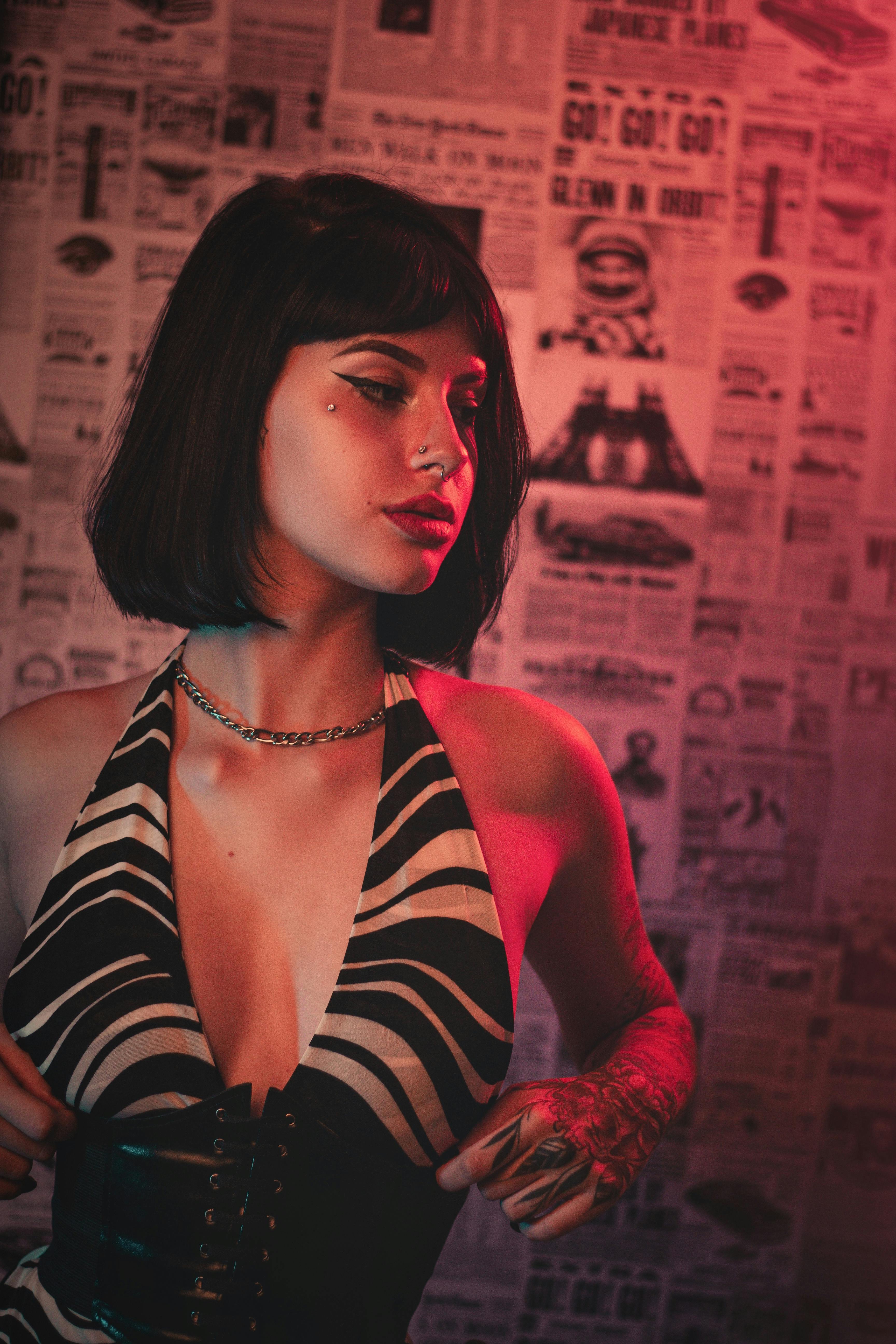 Stylish woman in a studio with vibrant lighting, showcasing modern fashion.