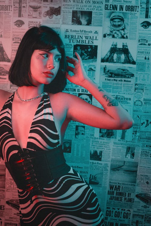 Free A woman in a zebra print dress posing in front of a newspaper Stock Photo