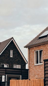 Close-up of modern homes with distinctive architecture under an overcast sky, showcasing residential design.