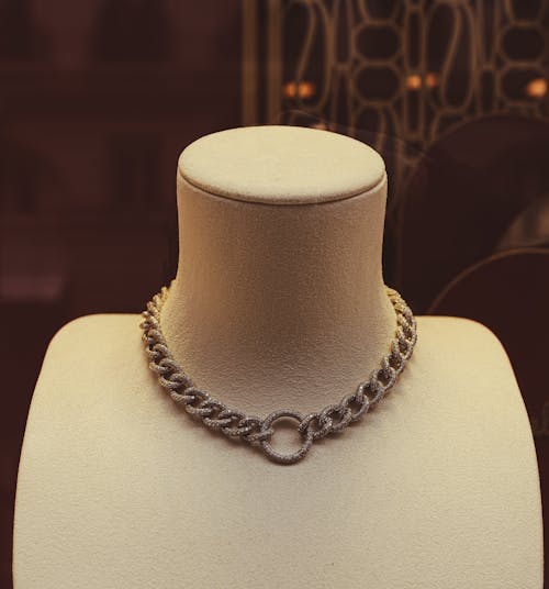 A necklace with a chain and a chain on display