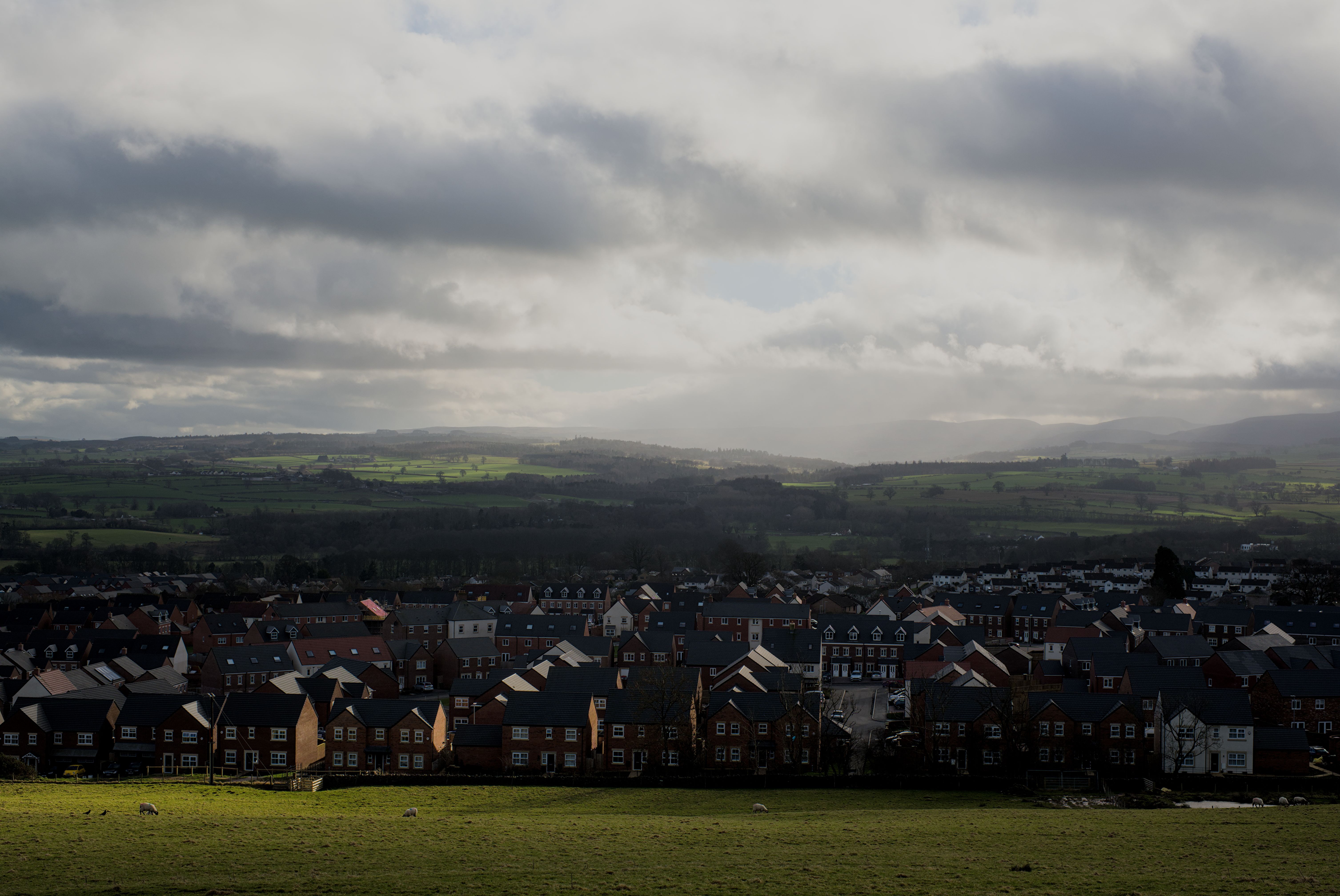 A captivating view of Penrith, England, showcasing rows of houses under dramatic cloudy skies.