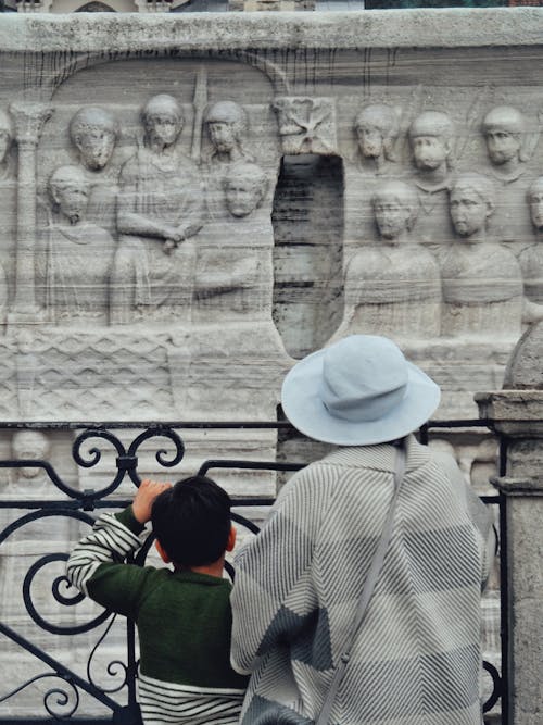 A woman and child looking at a statue