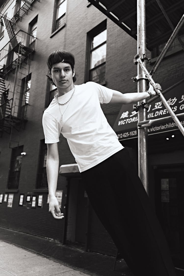 Man Leaning On Bar In Black And White