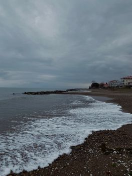 Peaceful coastline with overcast skies and gentle waves in a tranquil seascape.