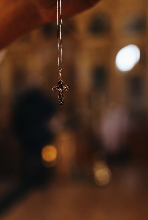 Free A close-up of a cross pendant against a blurred background, emphasizing faith and spirituality. Stock Photo