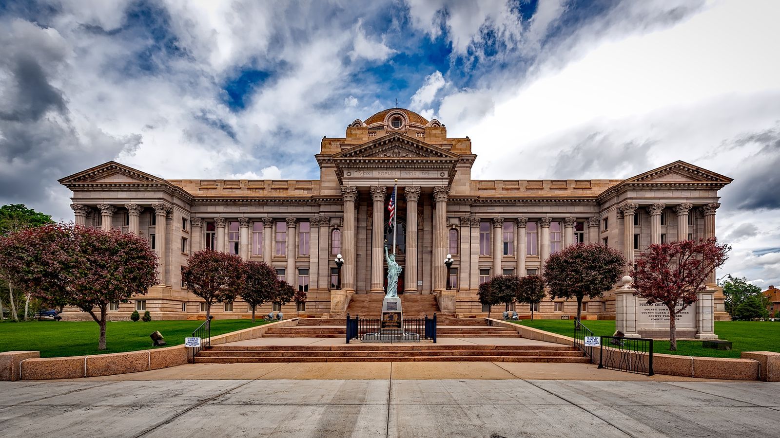 Front view of a neoclassical courthouse building in Colorado with lush greenery.