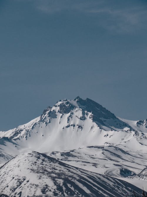 A snow covered mountain with a blue sky in the background