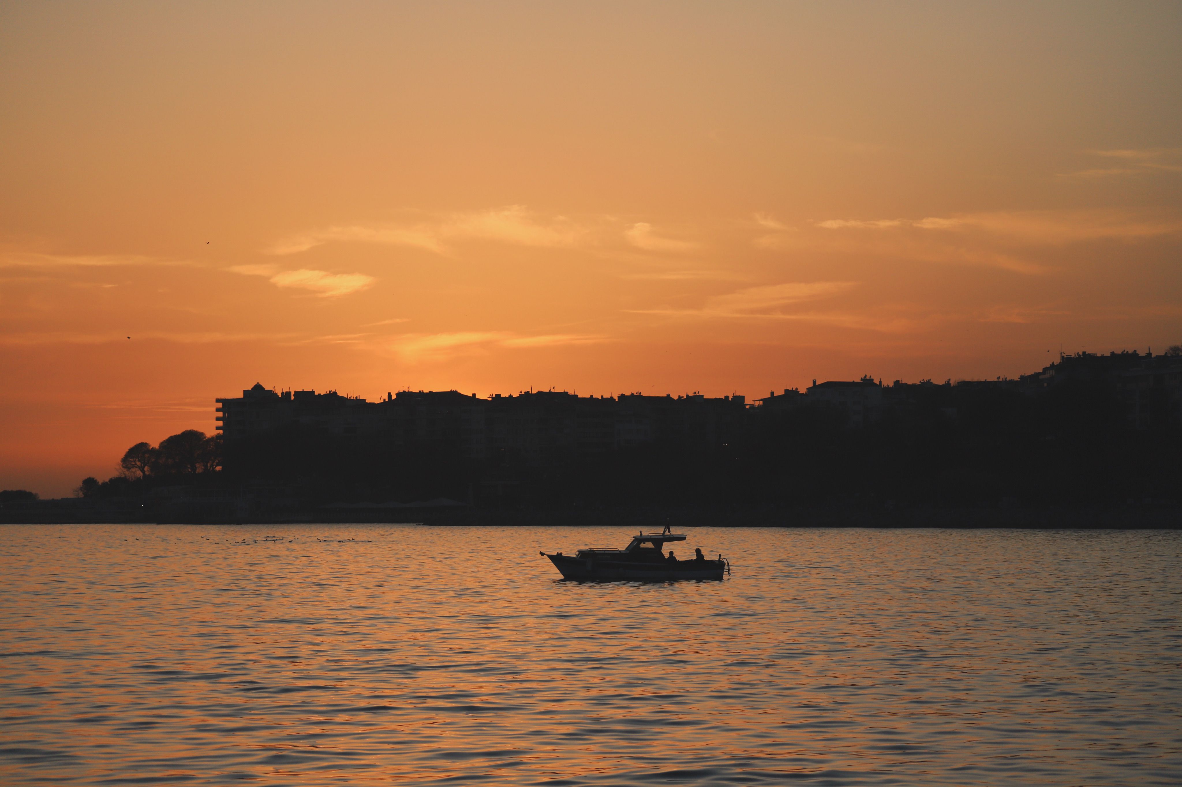 Boat Anchored in the Bay of a Seaside Town at Dusk · Free Stock Photo
