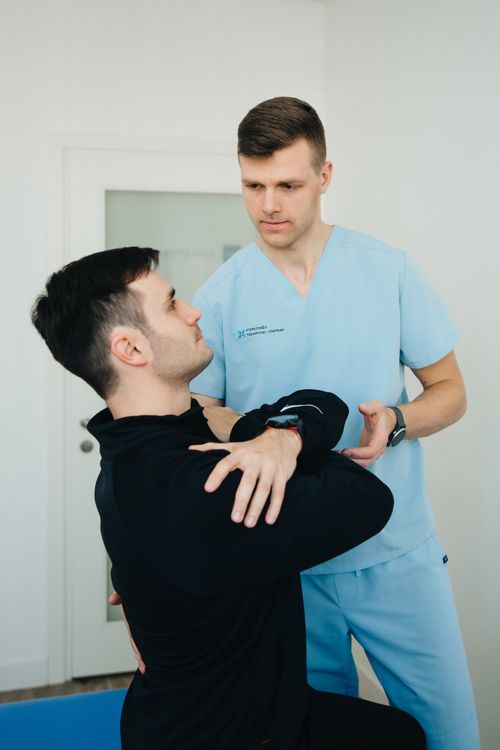 Free Physiotherapist assists a patient in therapeutic exercises indoors. Stock Photo