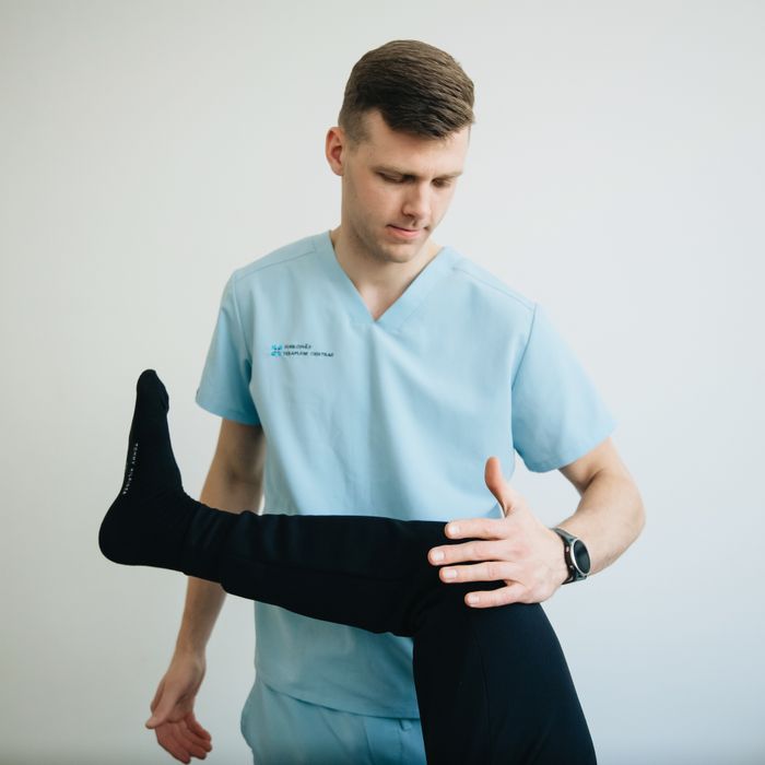 Fisioterapeuta trabajando la rodilla de un paciente