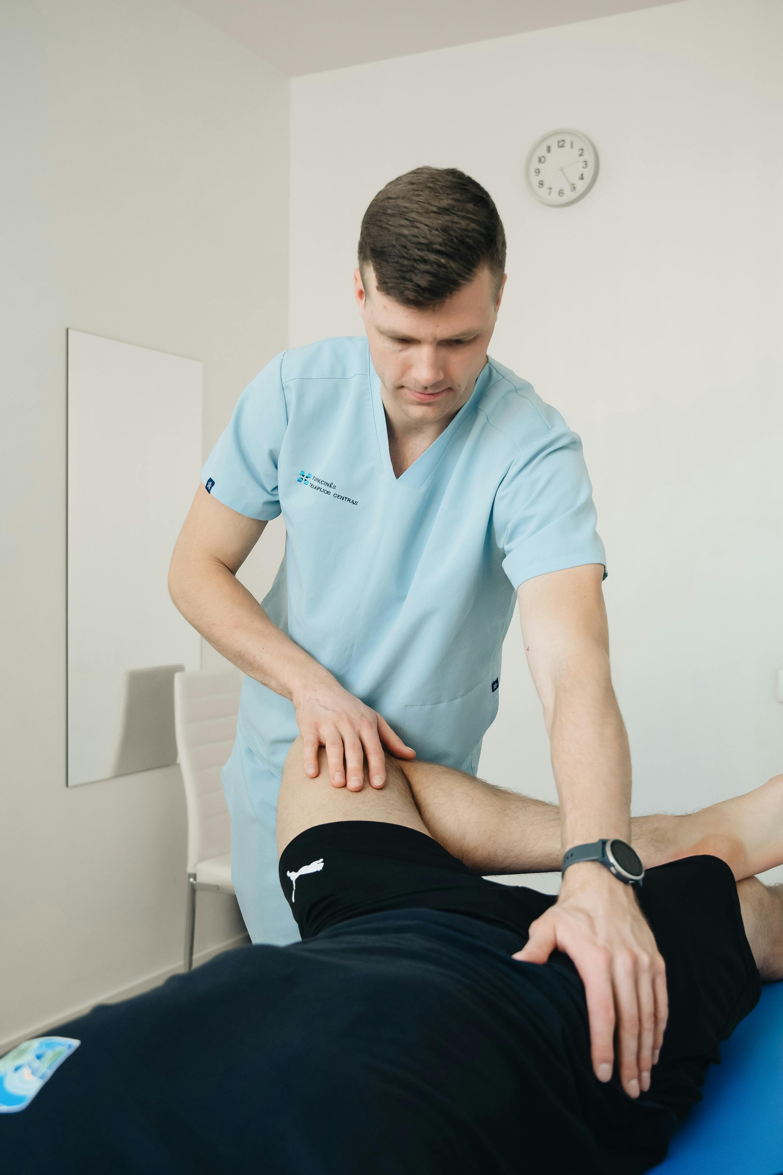 physiotherapist massaging leg and hip