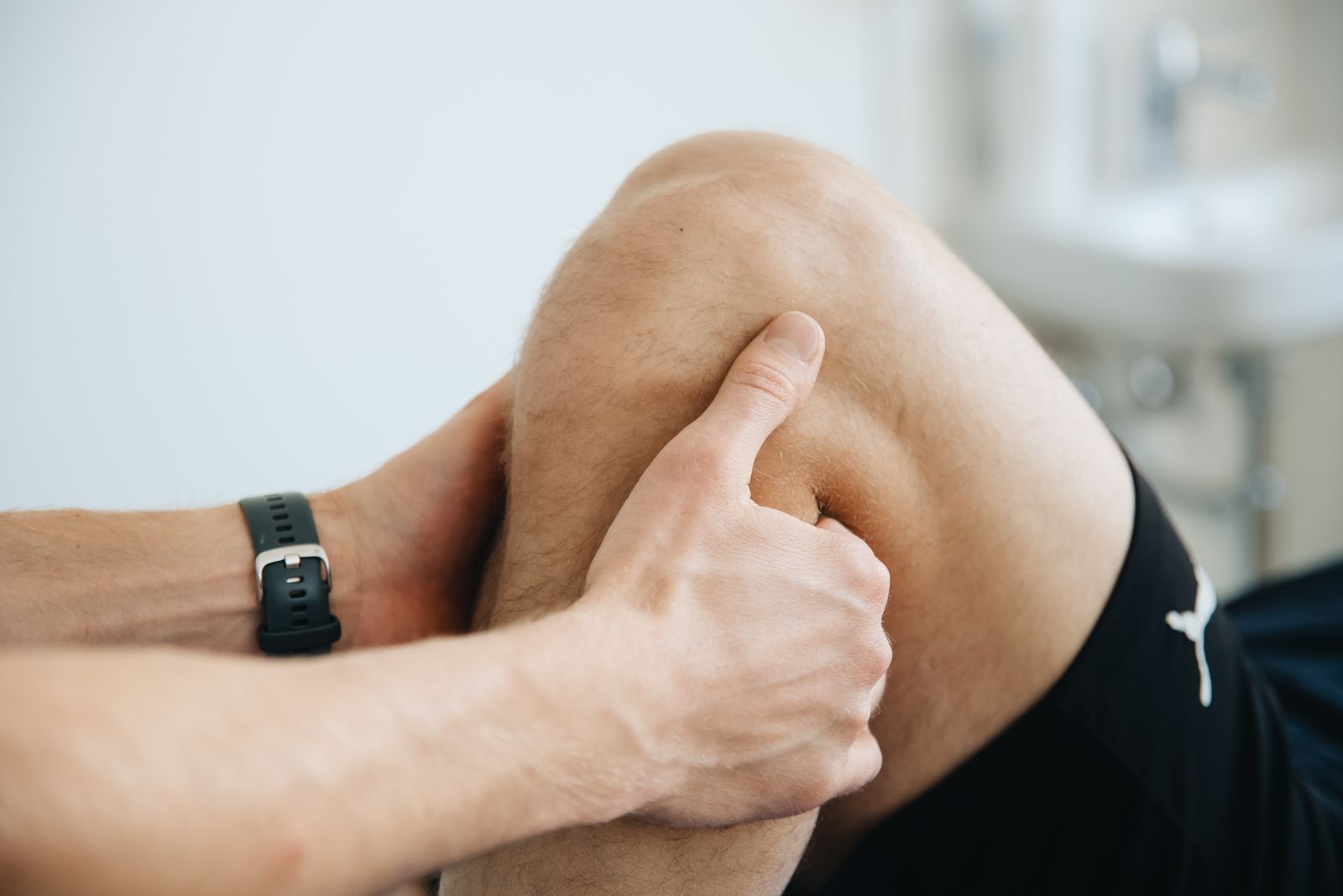 A physiotherapist treating a patient knee during a therapy session