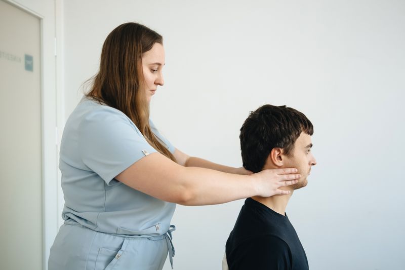 Physiotherapist assessing the neck of a patient with cervical radiculopathy and radiating arm pain