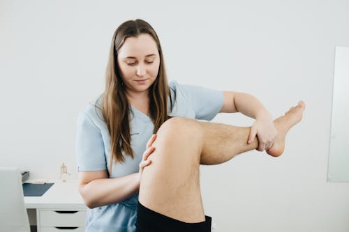 Free A woman is doing a massage on a man's leg Stock Photo