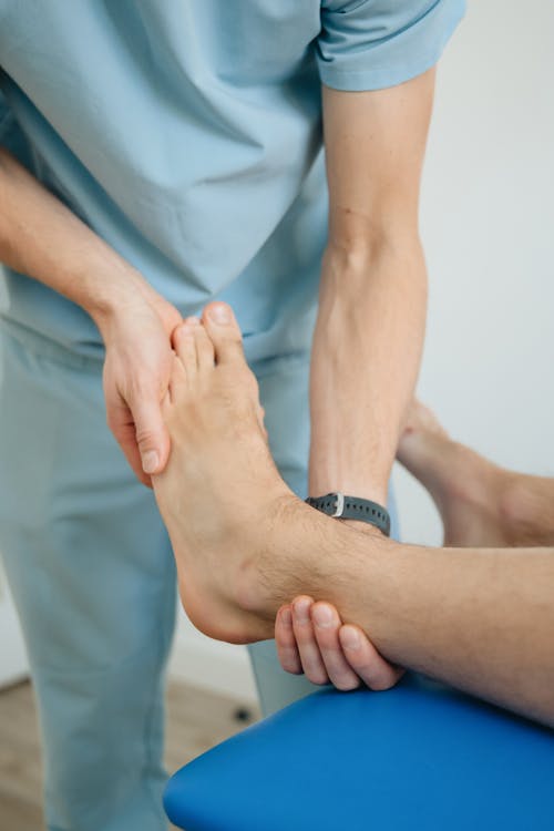 A man is getting his foot examined by a doctor