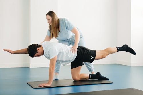 A man doing a plank exercise with a woman