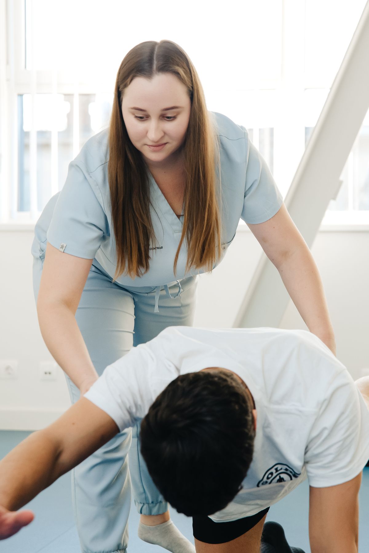 Physiotherapist guiding a patient through therapeutic exercise